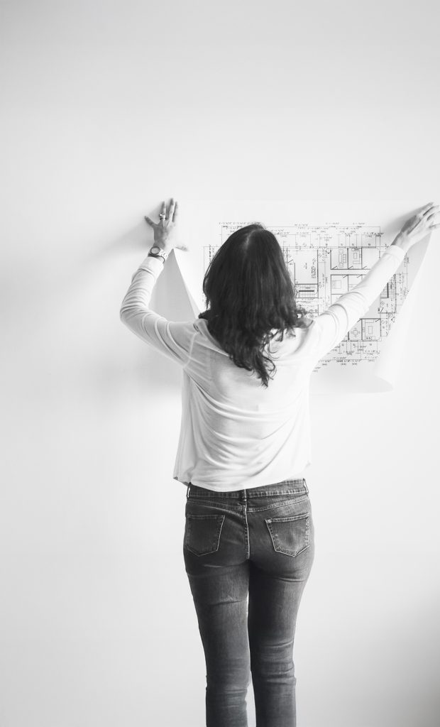 mujer mostrando edificio plano en la pared