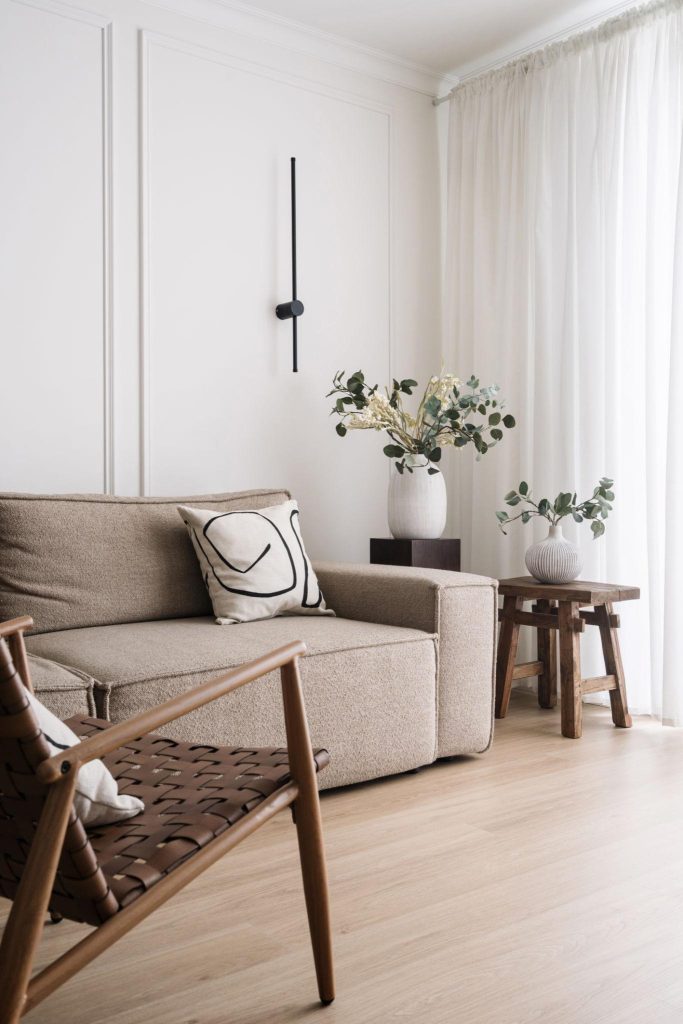 Salón minimalista donde los tonos neutros, la madera natural y los textiles suaves crean una atmósfera serena y acogedora. Las líneas limpias y la luz filtrada aportan equilibrio, calidez y elegancia atemporal.